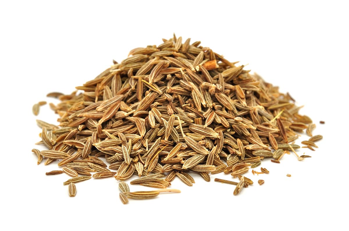 A Pile Of Caraway Seeds On A White Background