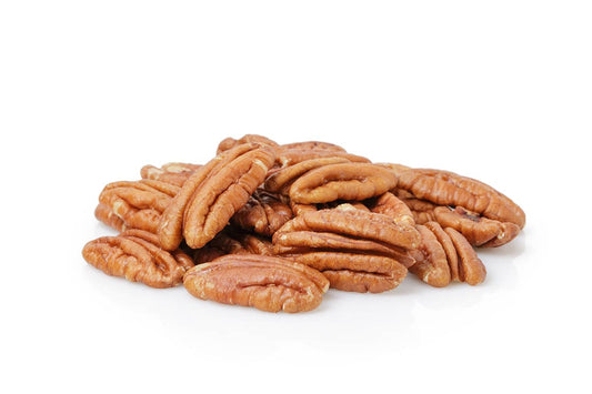 A small pile of shelled pecans is arranged on a white background. The pecans are a light brown color with a ridged texture, characteristic of nut meats. The image highlights the natural details and smooth surfaces of the pecans.