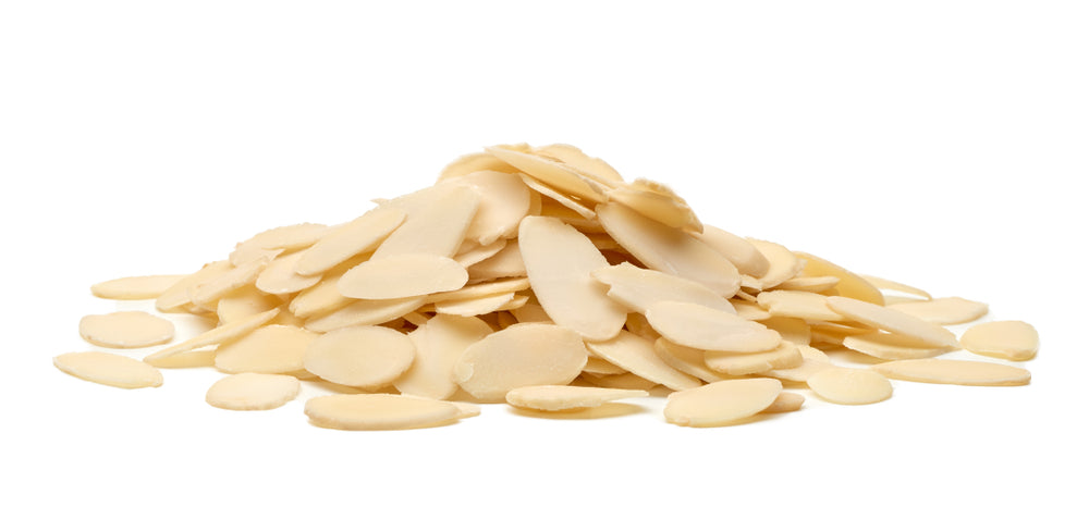 A pile of sliced flacked almonds isolated on a white background.